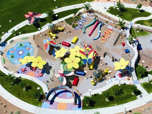 Overhead view of colorful butterfly wing shade structure with vibrant fabric panels at playground