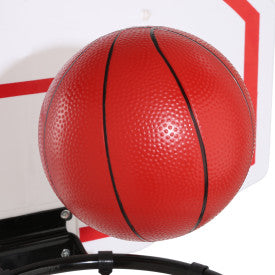 Textured red basketball resting on a black hoop attached to a white backboard with red trim