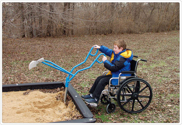 Child in wheelchair using blue ADA-compliant sandbox digger with molded aluminum shovel and 360-degree rotating seat