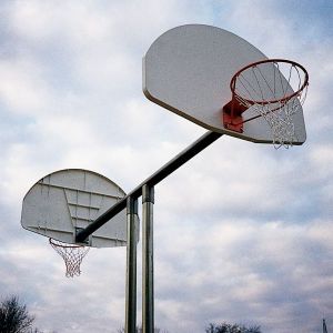 Double basketball goal with aluminum fan backboards and galvanized steel posts under cloudy sky