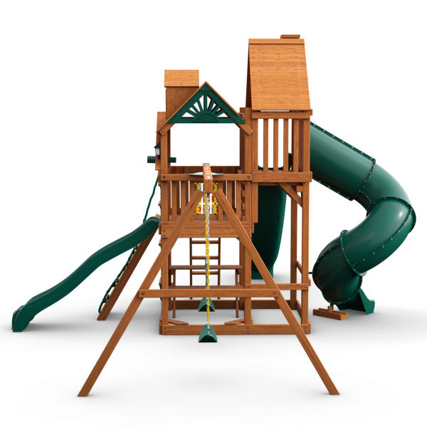 Cedar wooden playset with two green slides, trapeze swing, climbing ladder, and elevated playhouse with wood roof