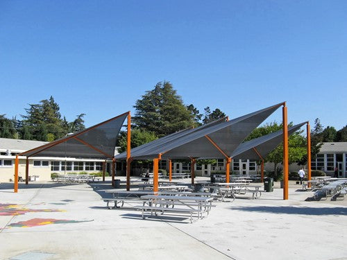 Wave Shade Structure with 4 Posts featuring colorful wave-shaped fabric canopies over outdoor picnic tables in a school courtyard