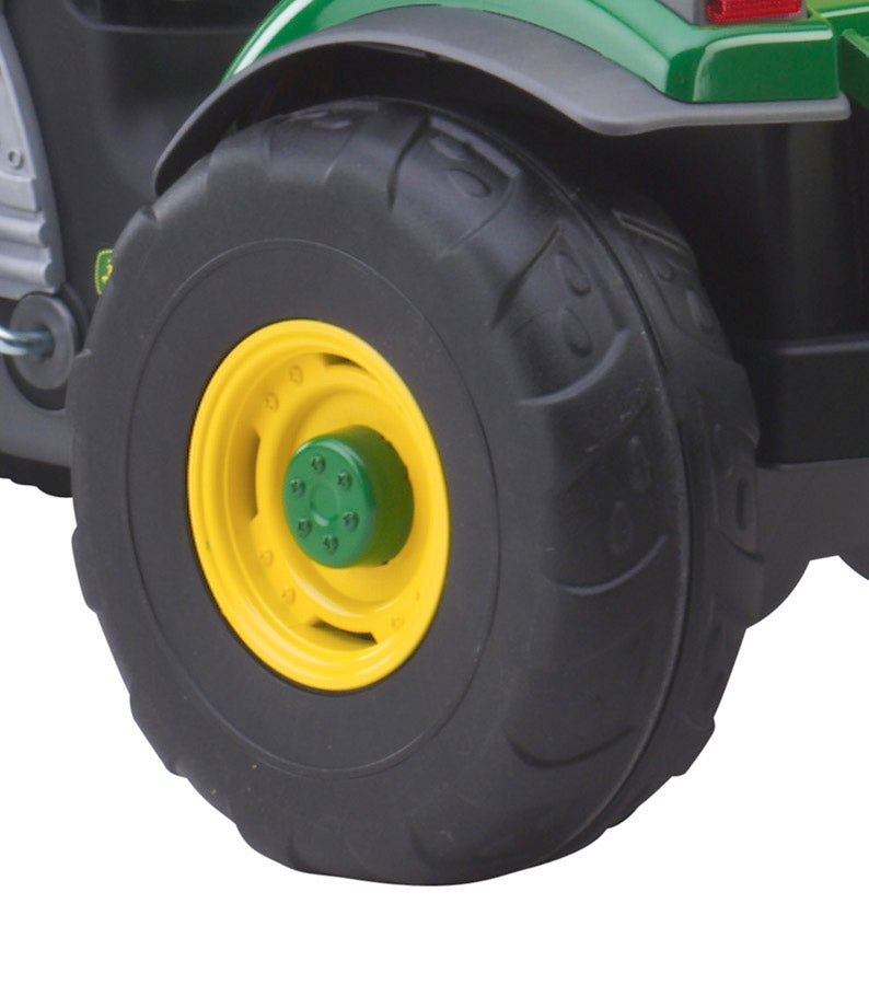 Close-up of black rubber tire with yellow rim on green children's pedal tractor toy wheel