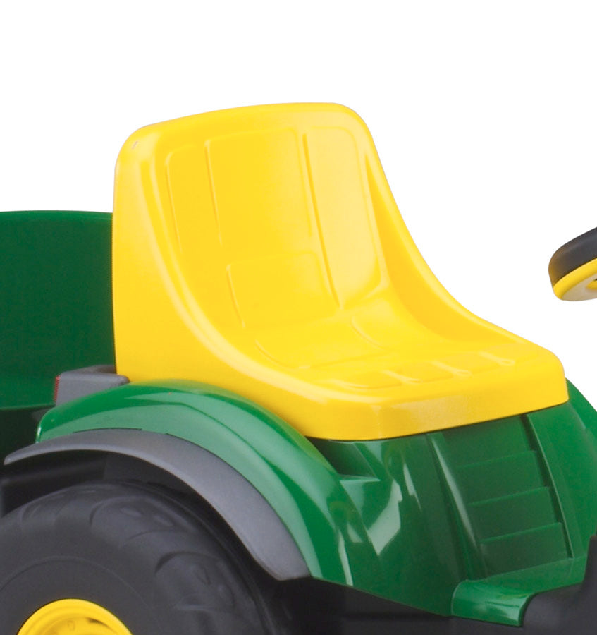 Child-sized green and yellow pedal tractor with large black wheels, yellow seat, realistic dashboard, and detachable green trailer