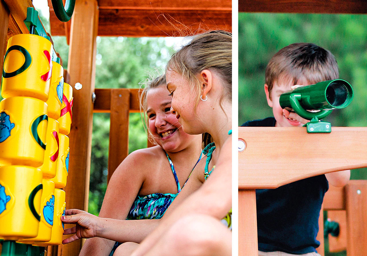 Children playing on a wooden playset with tic-tac-toe panel and green binoculars mounted on the railing
