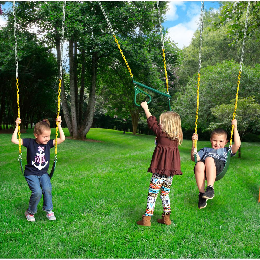 Three children playing on green belt swings and a trapeze bar with yellow chains in a grassy backyard with trees