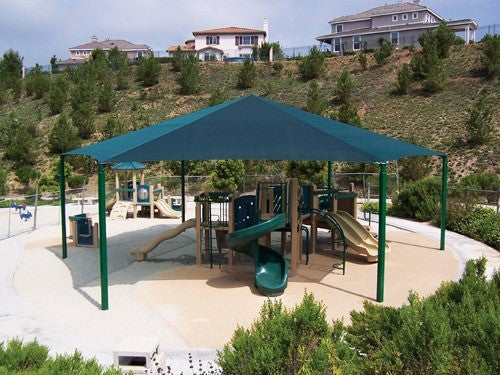 Hexagon shade structure with six green posts covering playground slides and climbing equipment