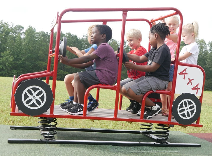 Red multi-passenger spring rider shaped like a 4x4 vehicle with children playing outdoors on grass