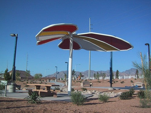 Butterfly Wings Down Shade Structure with colorful fabric panels providing shade in a desert park setting
