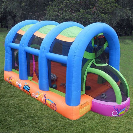 Inflatable sports bounce house with blue arches, orange base, soccer goals, and basketball hoops on grass
