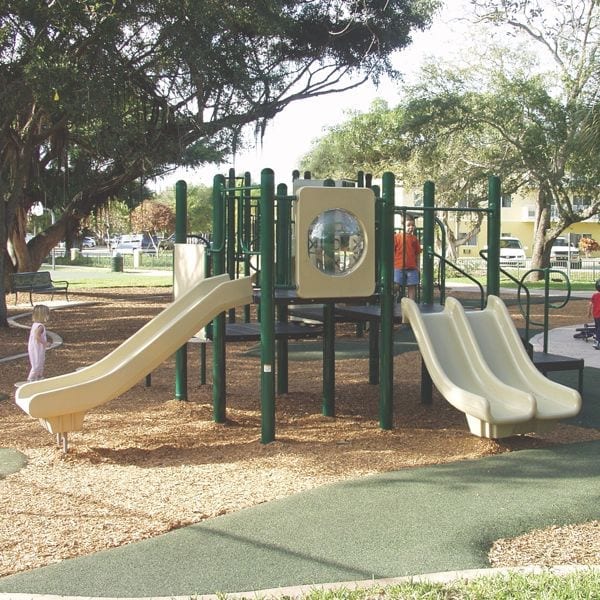 Playground with wide straight slide, double slide, climbing elements, and interactive activity panels in a park setting