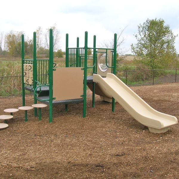 Outdoor modular playground with green steel posts, beige slides, tic tac toe panel, stepping stones, and bubble panel on wood chip ground