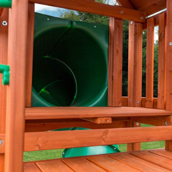 Redwood-finished cedar wooden playset frame with green tube slide entrance on outdoor grass