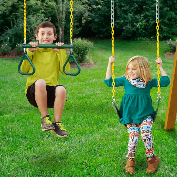 Two children playing on a cedar wooden swing set with two traditional swings and a trapeze bar on grass