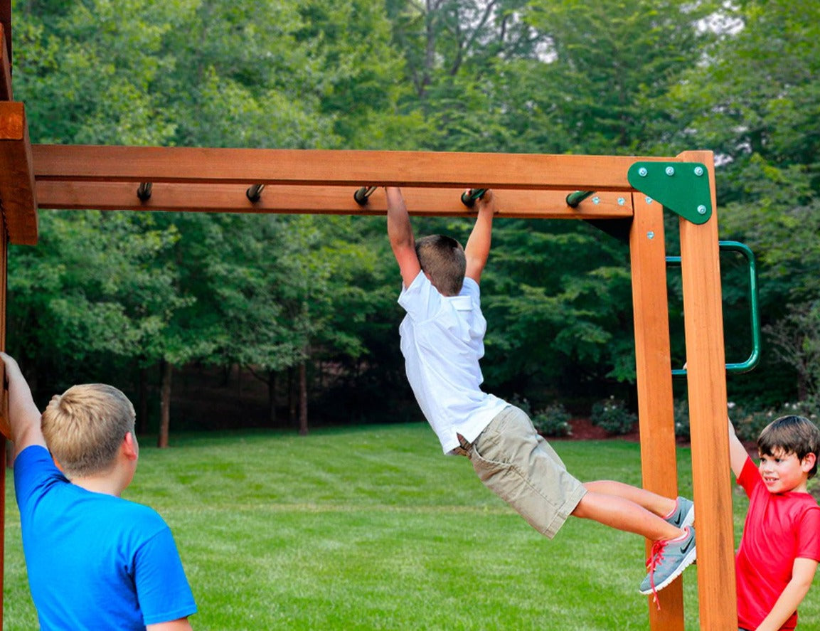 Three boys playing on wooden monkey bars with heavy-duty metal rungs in a green backyard setting