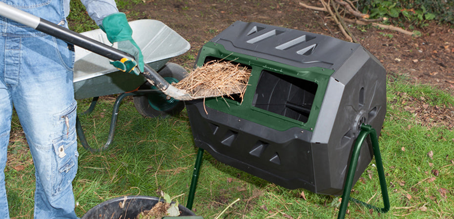 Mr. Spin Dual Compartment Compost Tumbler with green sliding door on tubular steel frame, person adding garden waste