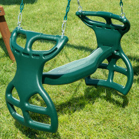 Green dual-seat glider swing with two handles and footrests, suspended by chains over grass, designed for two children