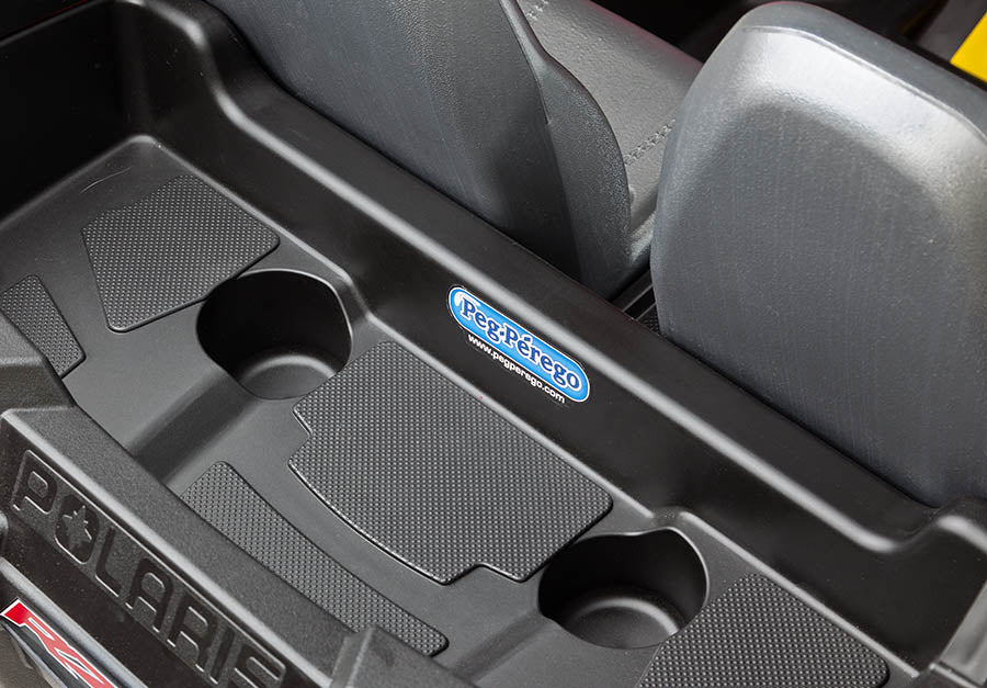 Black plastic cup holders and storage compartment with Peg Perego logo on Polaris RZR 900 ride-on vehicle seat area