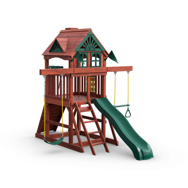 Wooden playset with redwood finish, green Alpine Wave slide, two belt swings, trapeze bar, rock wall, and clubhouse with decorative roof details