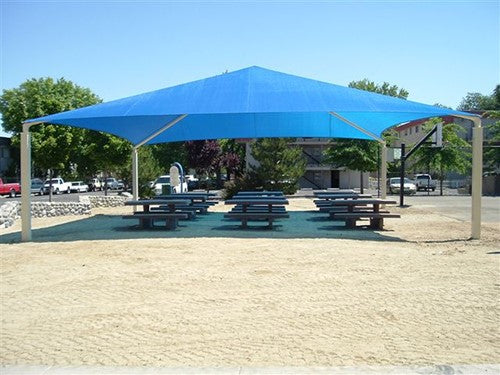 Blue pyramid roof shade structure with four posts covering picnic tables in an outdoor park setting