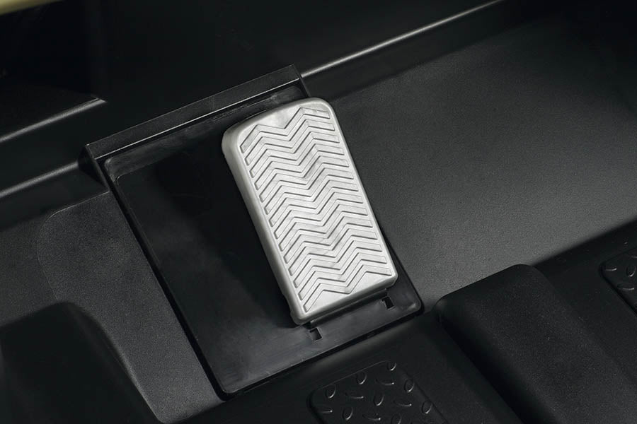 Textured silver foot pedal on black base of a kids' camo ride-on vehicle with rugged design details