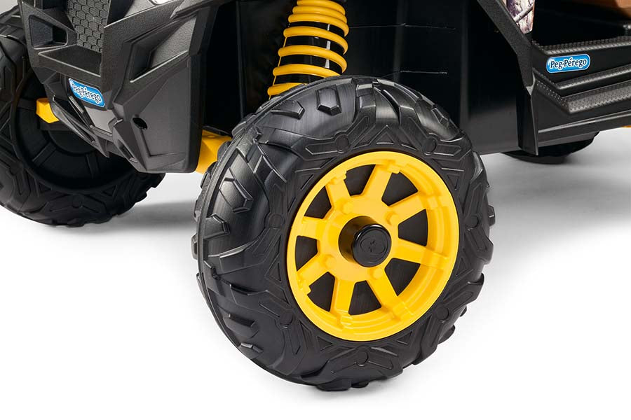 Rugged black and yellow off-road tire and suspension on a children's camo ride-on vehicle