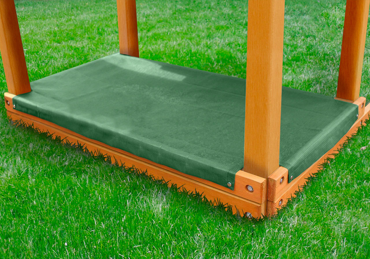 Green heavyweight mesh sandbox cover with stainless steel snaps secured on wooden sandbox frame outdoors