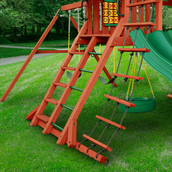 Cedar wooden swing set with climbing ladder, rope ladder, tire swing, and green double slides on grass