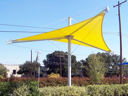 Yellow single post shade structure with tensioned fabric top supported by cables and turnbuckles outdoors