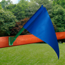 Blue canvas flag on green pole mounted to wooden swing set beam, surrounded by grass and trees