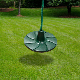 Green round textured disc swing hanging by rope over grass lawn