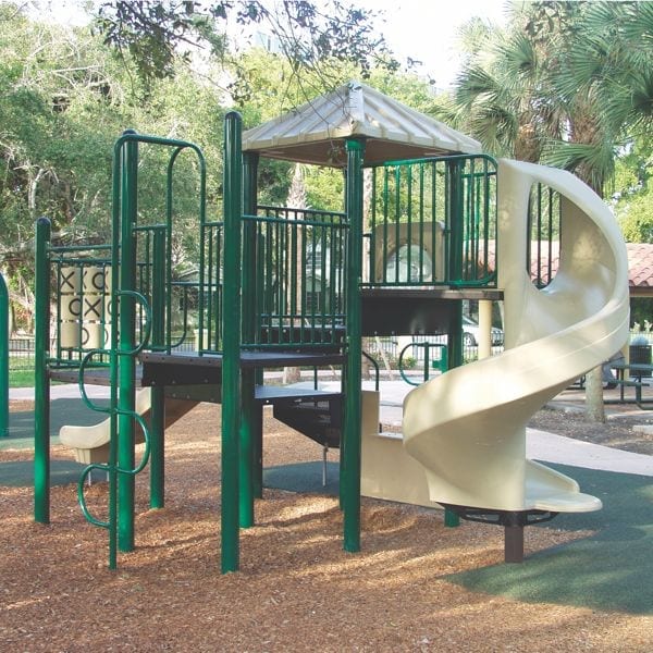 Outdoor modular playground with green posts, beige spiral slide, tic tac toe panel, bubble panel, and climbing ladder surrounded by trees