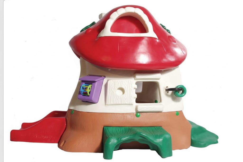 Mushroom Kottage colorful toddler playhouse with red mushroom roof, slide, green bench, purple activity panel, and whimsical Toad Stool chair