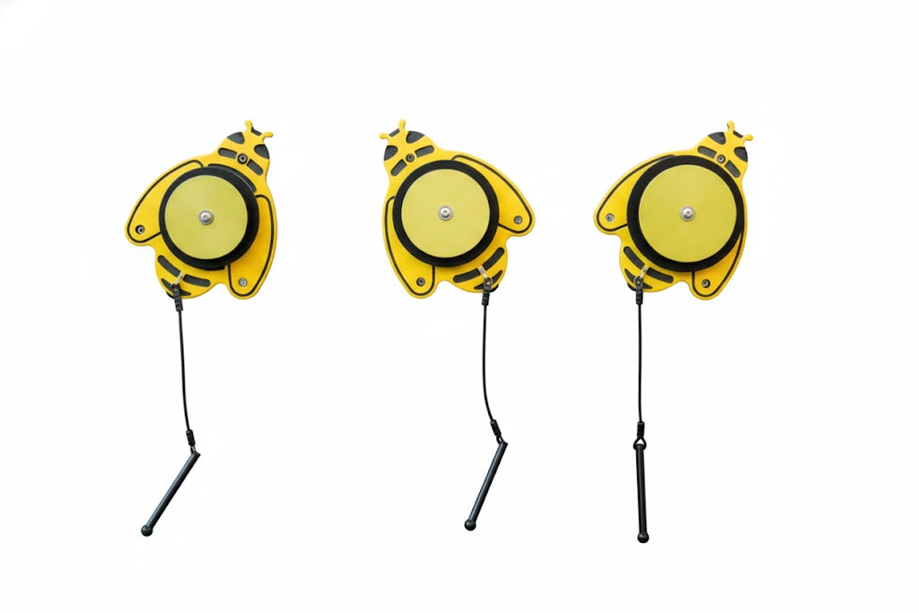 Melody Bees yellow bee-shaped outdoor musical instruments with attached mallets mounted on brick wall for interactive play