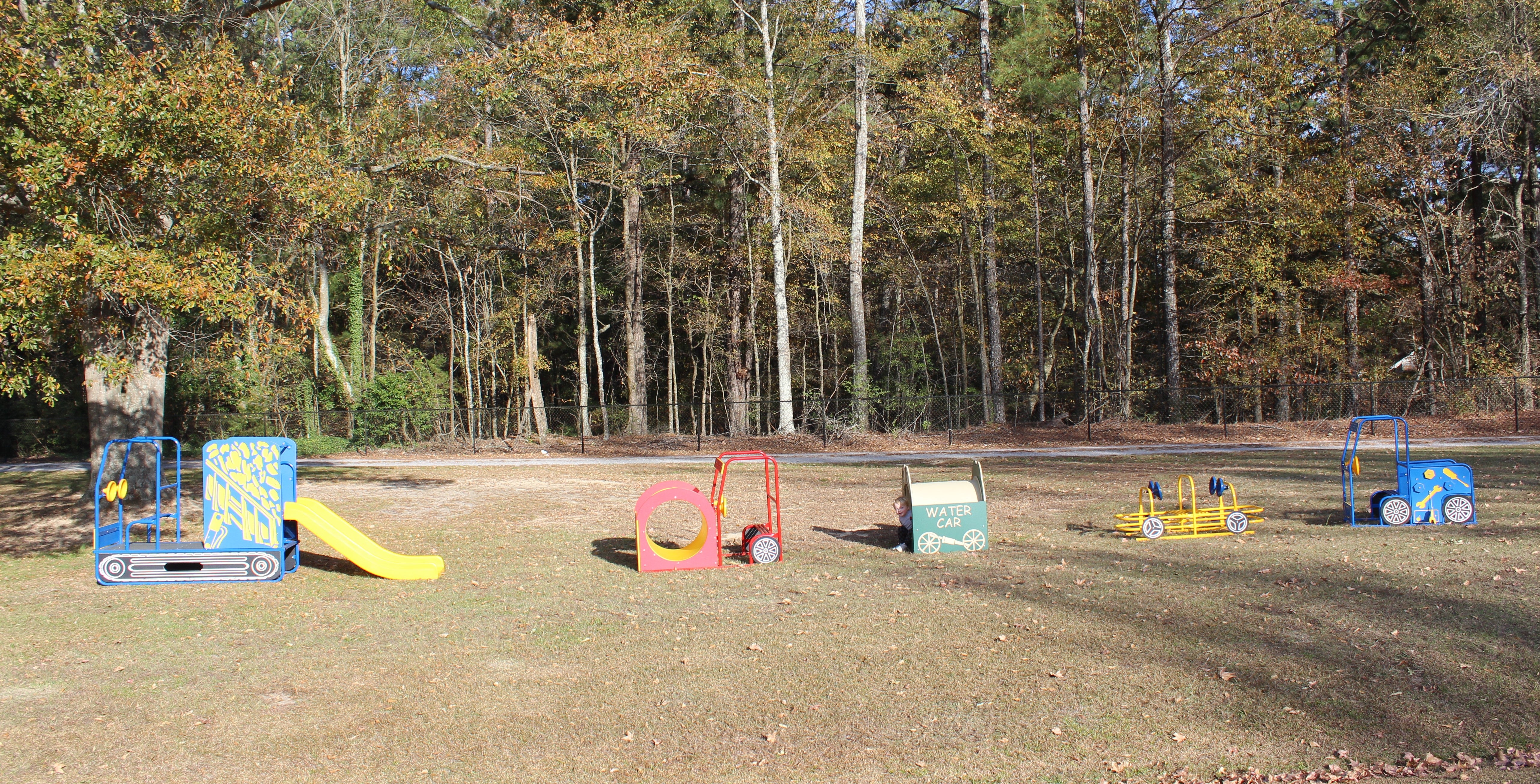 Road Crew Set - 5 Piece Fun Set with colorful construction-themed play structures on grassy playground near trees