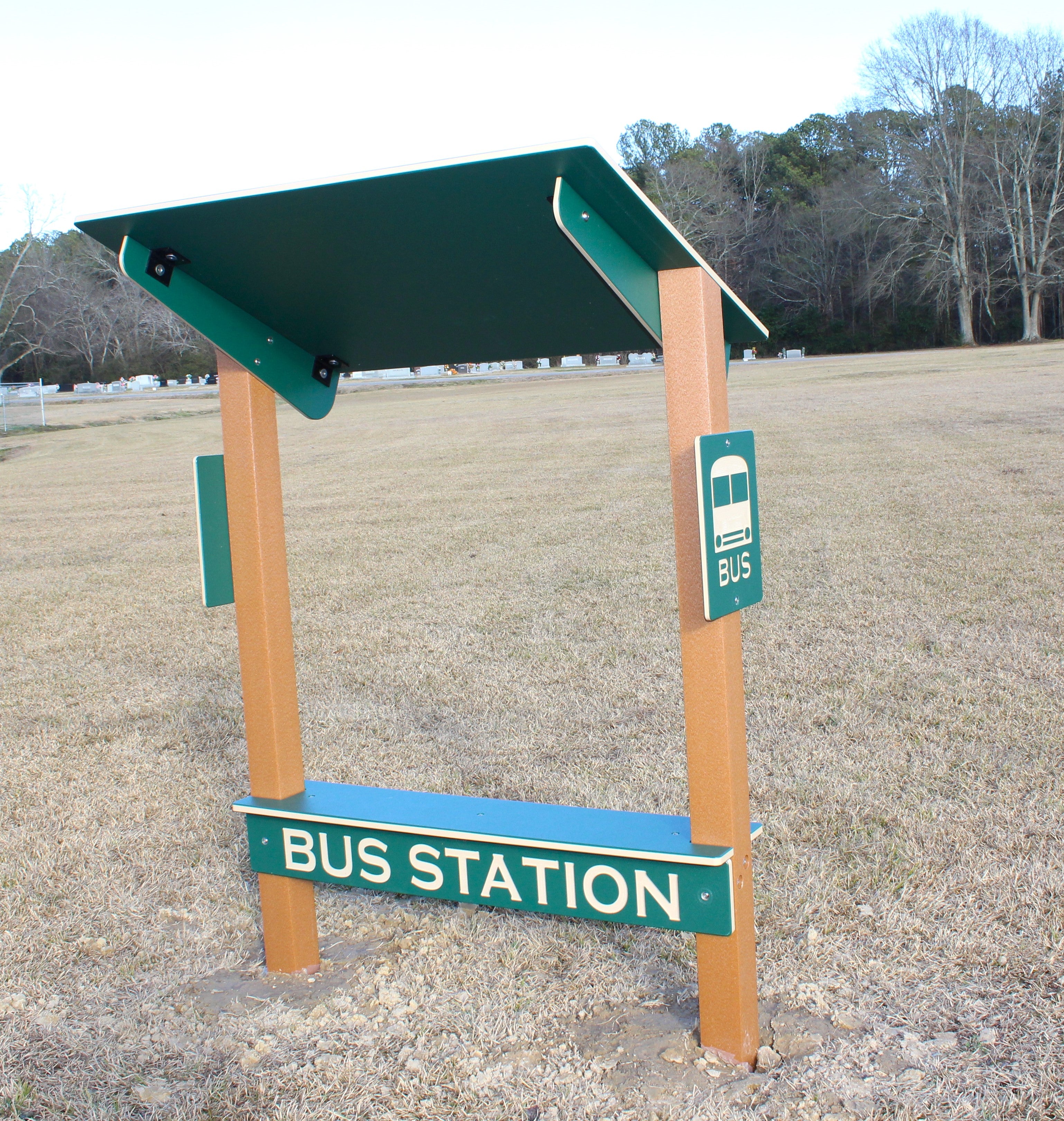 Bus Station Bench - Permanent with green roof, beige posts, bus sign panels, and shaded seating in outdoor play area