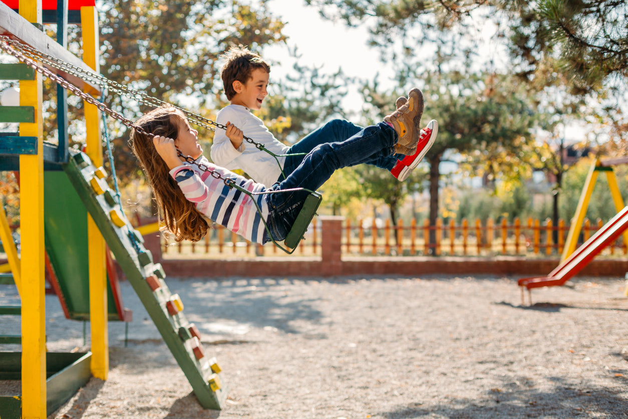 Kids Swinging on Playground Equipment