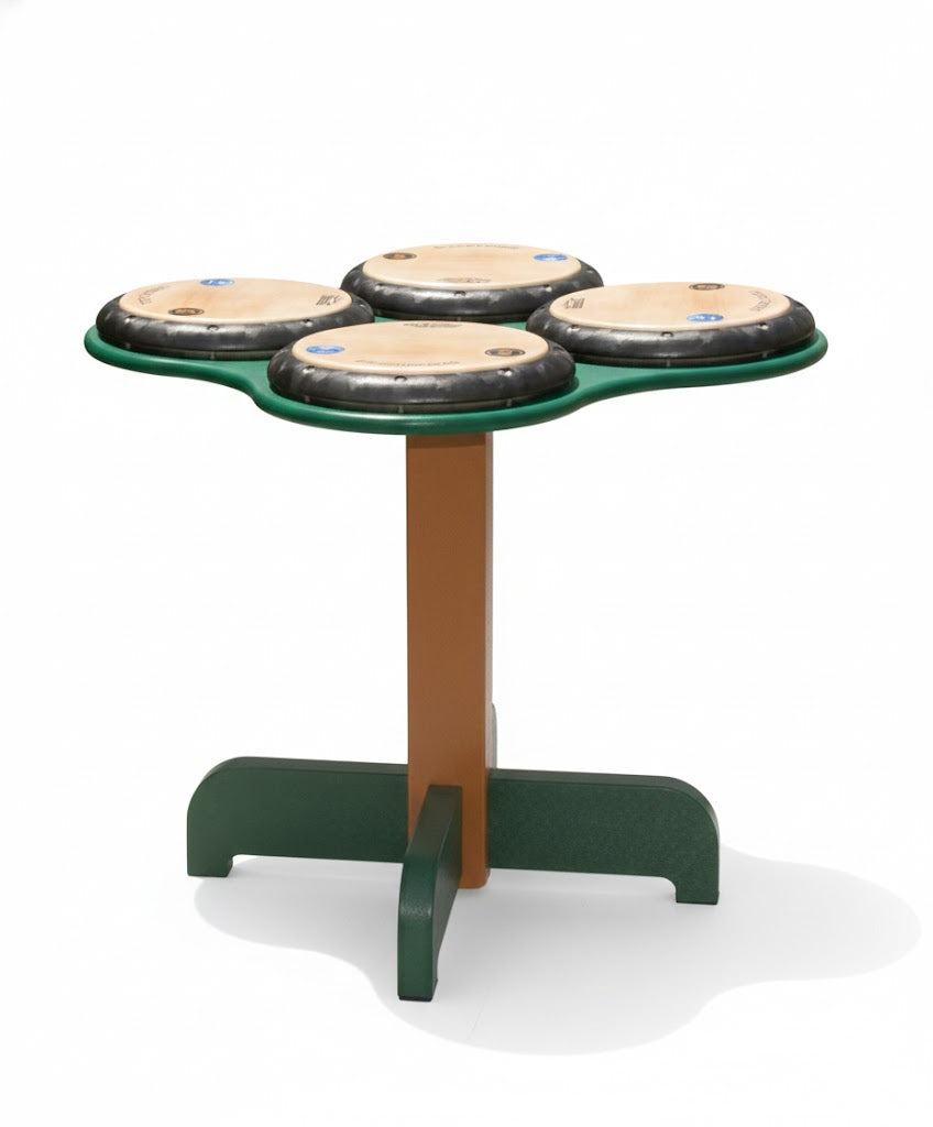 QuaDDDD Play Drum Table with four professional REMO drum heads on green and brown stand, outdoor interactive musical play surrounded by grass and plants
